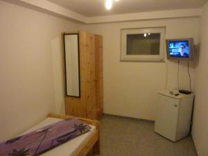 a room with a refrigerator and a tv on the wall at Ferienhaus Roy in Cologne