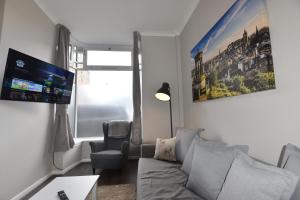 uma sala de estar com um sofá e uma cadeira em Pleasance Apartment Ground Floor Main Door Access em Edimburgo