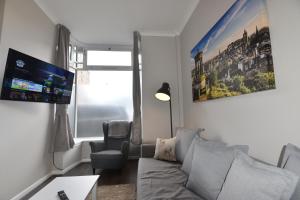 una sala de estar con un sofá y una silla en Pleasance Apartment Ground Floor Main Door Access, en Edimburgo