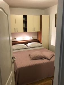 a bedroom with a bed with a mirror above it at Apartman Dvor in Makarska