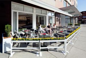a group of people sitting at tables outside a building at NU Hotel in Brooklyn