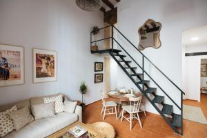 sala de estar con escalera y mesa en Casa Galera Historic Downtown Apartment in Seville en Sevilla