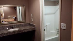 a bathroom with a sink and a mirror and a tub at Royal Relax Inn in Fairmont City