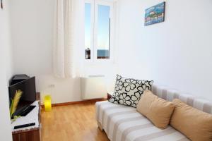 ein Wohnzimmer mit einem Sofa und einem Fenster in der Unterkunft Apartma Dante in Piran