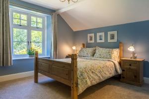 a bedroom with blue walls and a bed and a window at Strelna Coach House - Gateway to the Moor, Dartmoor in Bovey Tracey