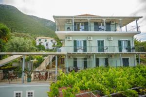 a large white building with balconies and trees at Ionian Melody in Nikiana