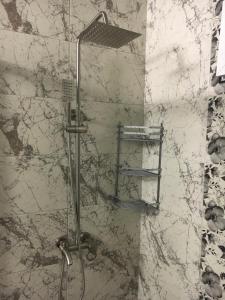 a shower in a bathroom with a marble wall at Guest House Lazuri in Sarpi +41 photos