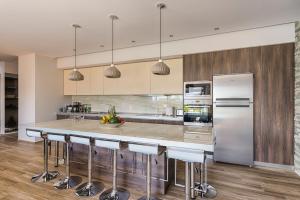 a kitchen with a large island with bar stools at Nastazia Luxury Beach House in Ialyssos +26 photos
