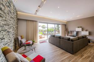 a living room with couches and a stone wall at Nastazia Luxury Beach House in Ialysos