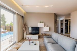 a living room with a couch and a tv at Nastazia Luxury Beach House in Ialysos