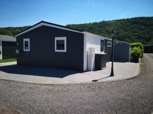 a black and white building with a driveway at Ferienhaus MaLeFi 1 am Gülser Moselbogen in Koblenz