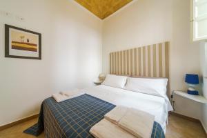 マルサラにあるMia Apartmentsのベッドルーム(白いベッド、青い毛布付)