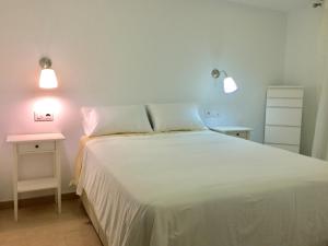 sypialnia z dużym białym łóżkiem z 2 światłami w obiekcie Casa Luz w mieście Tarifa