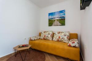 un sofá en una sala de estar con una pintura en la pared en Apartment NONNA, en Krk