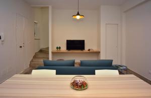 uma sala de estar com uma mesa e um sofá azul em Casa Tresca - Holiday Accommodations em Menfi