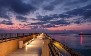 a pier with a view of the ocean at sunset at ADOSADO DE LUJO CON PISCINA PRIVADA en ZONA MUY TRANQUILA in Gandía