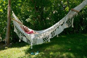 a man laying in a hammock in a yard at Le Goéland in Tadoussac