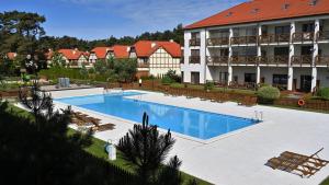 a large swimming pool in front of a building at Apartament Plaza 7 - Rezydencja Nadmorska Rogowo in Rogowo