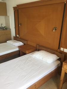two beds in a room with wood paneling at Diamond Beach Apts & Studios in Stalís
