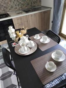 a black table with cups and saucers on it at Santa Rita in Casa Toscano