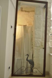 オストゥーニにあるLatorreangioinaの部屋に鳥が乗った鏡