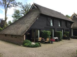 a black house with a thatched roof at Eursingerhof in Havelte