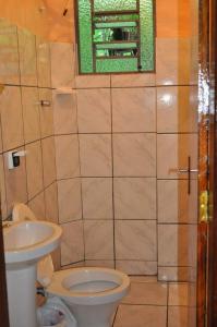 a bathroom with a toilet and a sink at Hospedagem Centro Champagnat in Londrina +4 photos