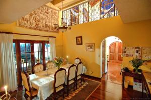 uma sala de jantar com uma mesa e cadeiras e uma janela em Cariari Bed & Breakfast em San José