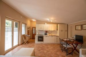 a kitchen with white cabinets and a table in a room at Un Giardino sul Lago in Montefiascone
