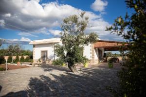 a tree in front of a white building at Villetta Mari con piscina esclusiva nel Salento in Capilungo