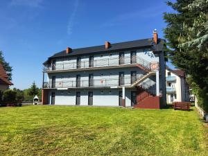 un grand bâtiment blanc avec une pelouse devant lui dans l'établissement Fala, à Karwia