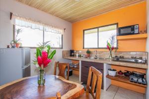 a kitchen with a wooden table with a vase of flowers at Casa Monarca - Monteverde in Monteverde Costa Rica
