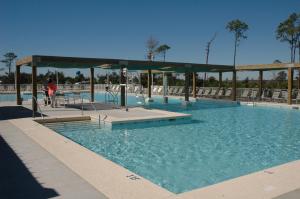 a large swimming pool with a person standing in the water at Eagle Cottages at Gulf State Park in Gulf Shores