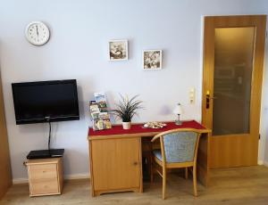 a room with a desk with a tv and a table with a desk at Ferienwohnung Ella in Ostseebad Sellin