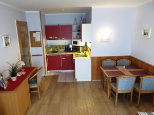 a kitchen and dining room with red cabinets and a table at Ferienwohnung Ella in Ostseebad Sellin