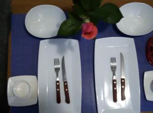 a table with two forks and plates on a table at Via Dinarica GuestHouse in Jablanica +26 photos