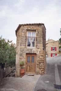 - un petit bâtiment en pierre avec une fenêtre et une porte dans l'établissement La petite maison, à Châteauneuf-du-Pape