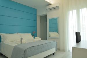 um quarto com uma cama com uma cabeceira azul em Dreams Tropea Mare "Parking Private" em Tropea