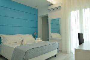 a bedroom with a bed with a blue headboard at Dreams Tropea Mare in Tropea