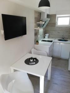 a living room with a white table and a tv at Apartment Kate in Bibinje