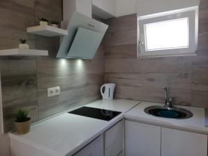 een kleine keuken met een wastafel en een raam bij Apartment Kate in Bibinje