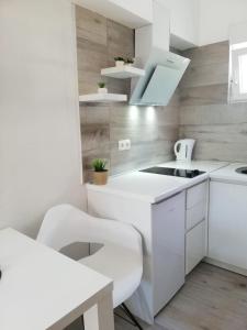een witte keuken met een wastafel en een fornuis bij Apartment Kate in Bibinje