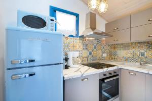 a kitchen with a blue refrigerator and a microwave at GLAROS BUNGALOW in Skala Kallirachis +13 photos