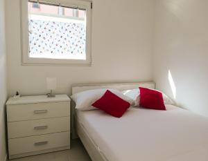 a bedroom with two beds with red pillows and a window at BUNGALOW VICE with pool in Pakoštane +51 photos