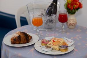 una mesa con dos platos de comida y dos vasos de zumo de naranja en Camping Village La Pineta, en San Vito lo Capo