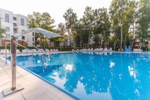 a swimming pool at a hotel with chairs and trees at Apartament Kristina Osiedle Polanki in Kołobrzeg