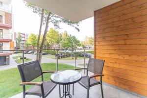 eine Terrasse mit Tisch und Stühlen auf einem Balkon in der Unterkunft Apartament Kristina Osiedle Polanki in Kołobrzeg