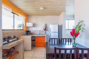 eine Küche mit einem Kühlschrank und einem Tisch mit Stühlen in der Unterkunft Casa Monarca II - Monteverde in Monteverde Costa Rica