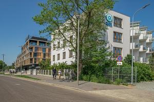 osoba idąca ulicą obok budynku w obiekcie Family Homes - Apartamenty Gwiazda Morza we Władysławowie