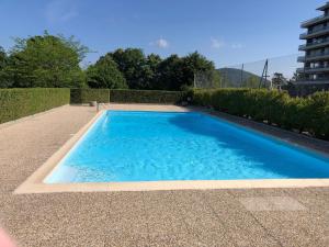 a large blue swimming pool in a yard at Les Terrasses de Tresserve in Aix-les-Bains